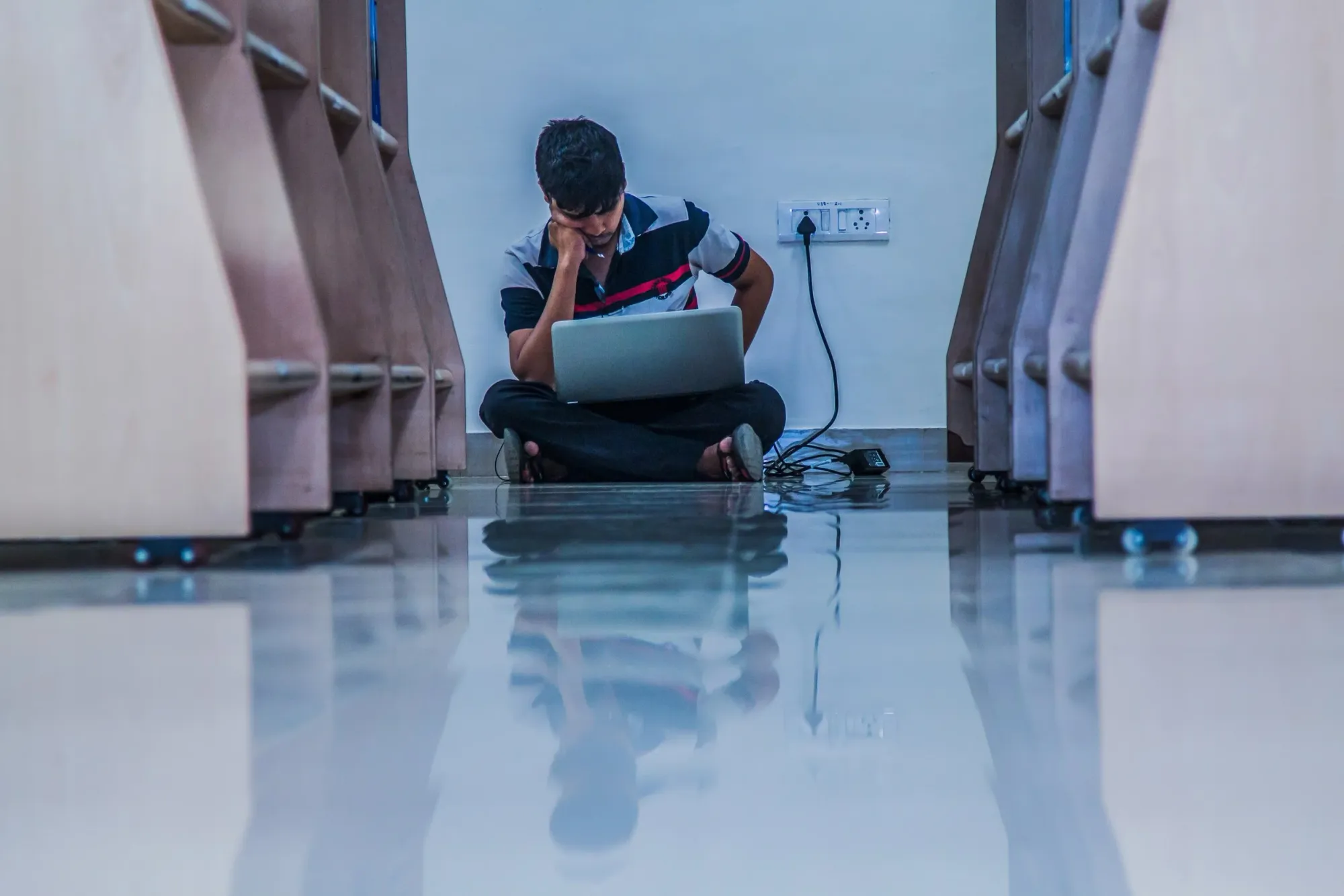 A person reading alone beside library bookshelves